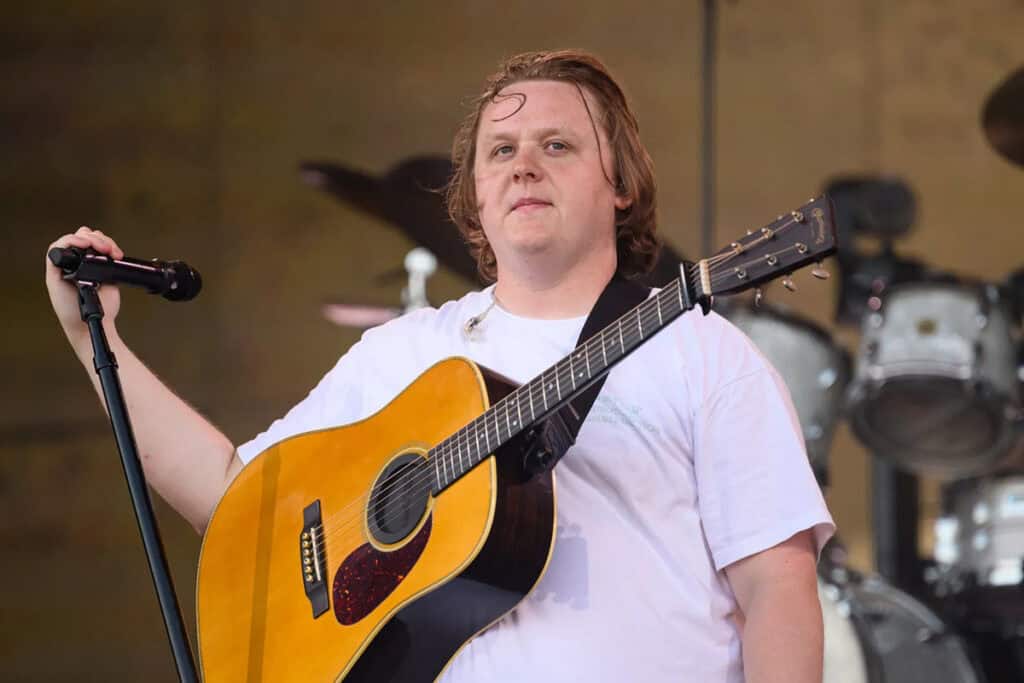The image shows Scottish singer-songwriter Lewis Capaldi performing on stage.