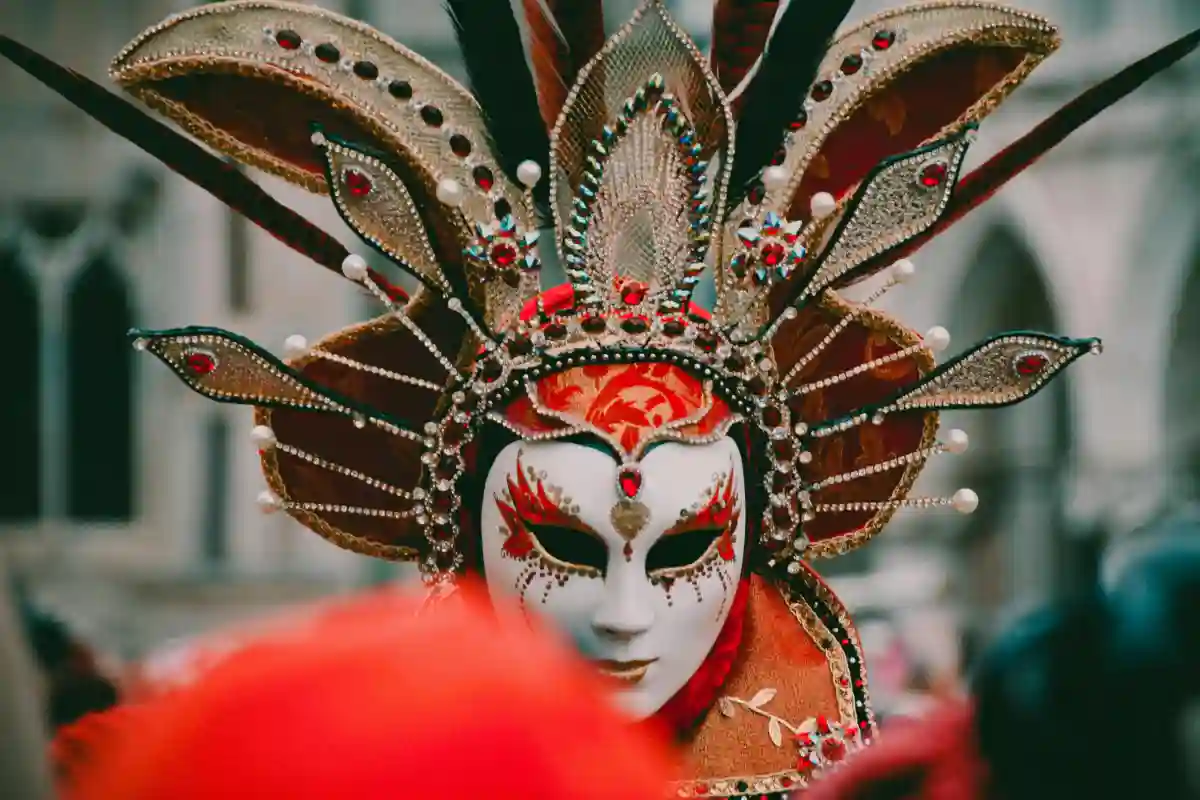 Person in white and orange Volto mask during Carnevale in Venice, Italy Person in white and orange Volto mask during Carnevale in Venice, Italy