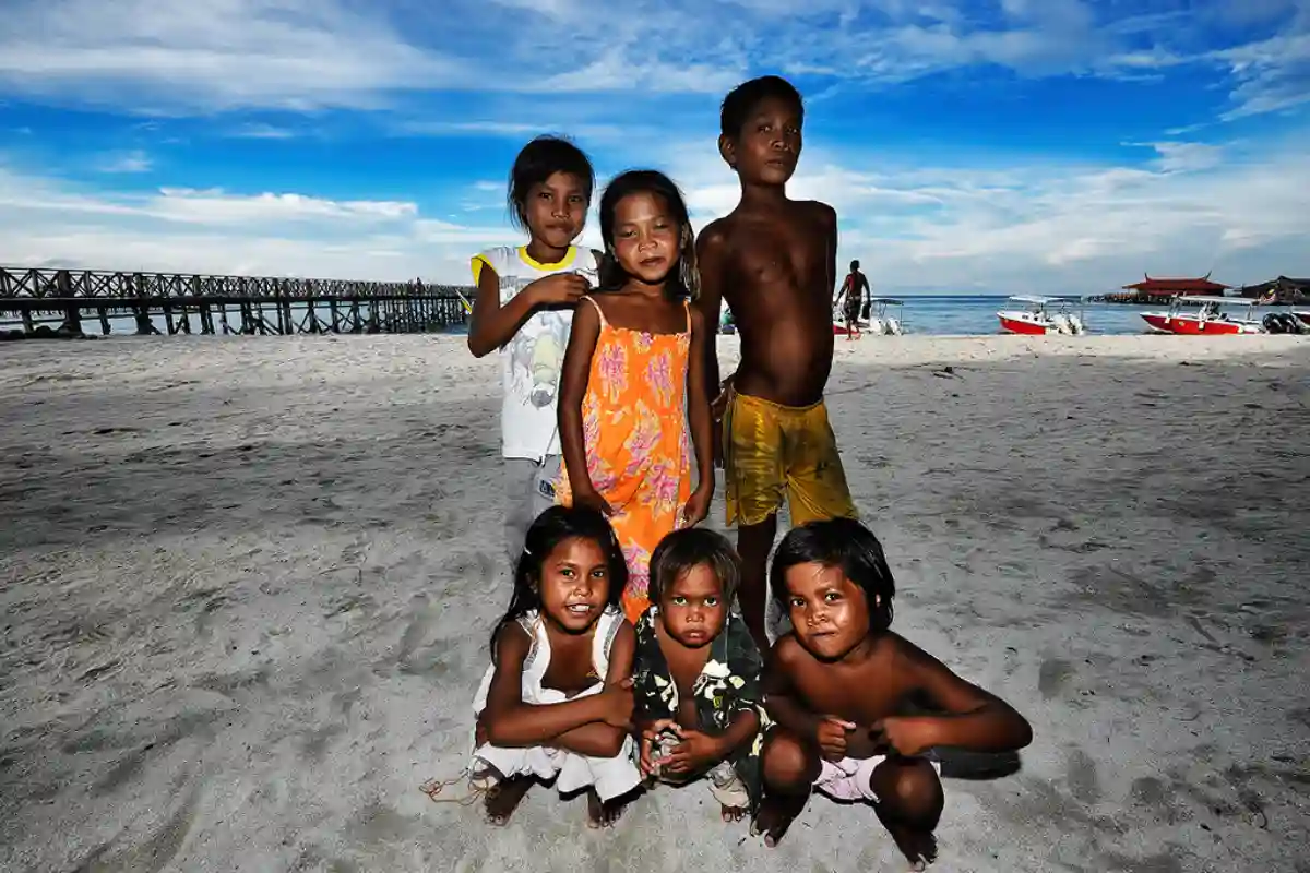 Bajau Laut children playing on a boat, with the vast ocean surrounding them, reflecting their carefree yet sea-bound childhood. Bajau Laut children playing on a boat, with the vast ocean surrounding them, reflecting their carefree yet sea-bound childhood.