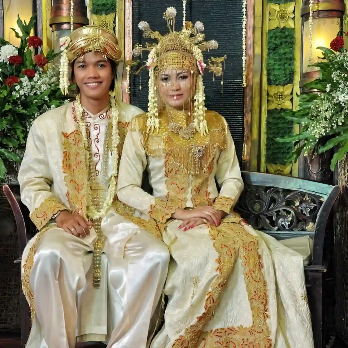 Traditional Betawi wedding dress with the bride in a gold-embroidered kebaya and a vibrant batik sarong, complemented by a classic headdress, representing Betawi cultural pride. Traditional Betawi wedding dress with the bride in a gold-embroidered kebaya and a vibrant batik sarong, complemented by a classic headdress, representing Betawi cultural pride.
