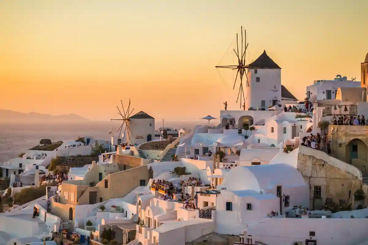 A Greek island scene with lost of people all gazing in the same direction. A Greek island scene with lost of people all gazing in the same direction.