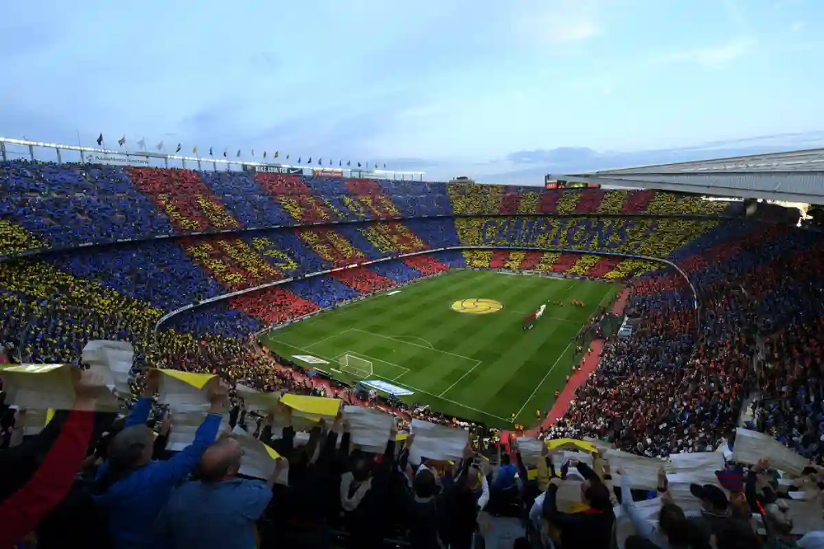 packed stadium during the El Clásico match between FC Barcelona and Real Madrid, with both teams' fans cheering passionately. packed stadium during the El Clásico match between FC Barcelona and Real Madrid, with both teams' fans cheering passionately.