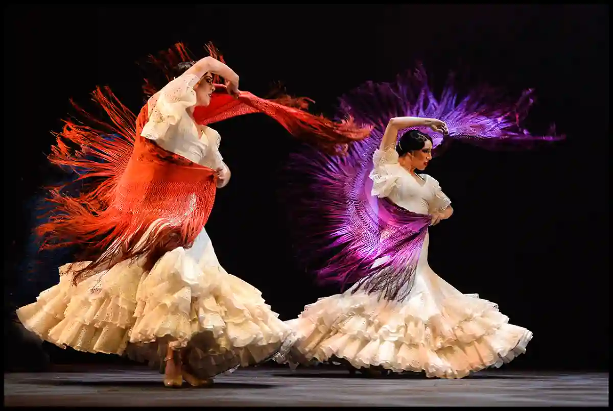 A passionate Flamenco dancer in a vibrant red dress performing with castanets and an intense expression. A passionate Flamenco dancer in a vibrant red dress performing with castanets and an intense expression.
