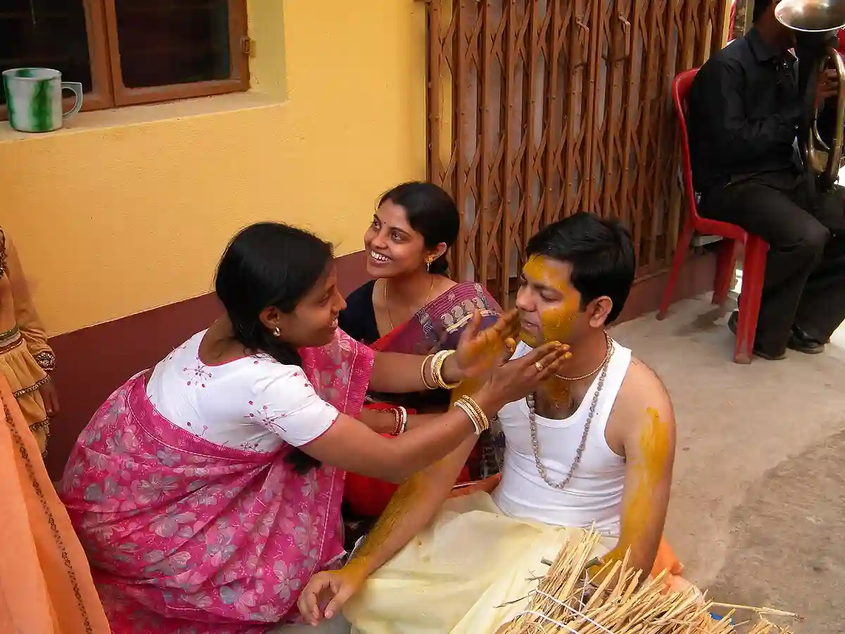 The bride and groom are smeared with turmeric paste during the Gaye Holud (Haldi) ceremony, a pre-wedding ritual in Bengali weddings. The bride and groom are smeared with turmeric paste during the Gaye Holud (Haldi) ceremony, a pre-wedding ritual in Bengali weddings.