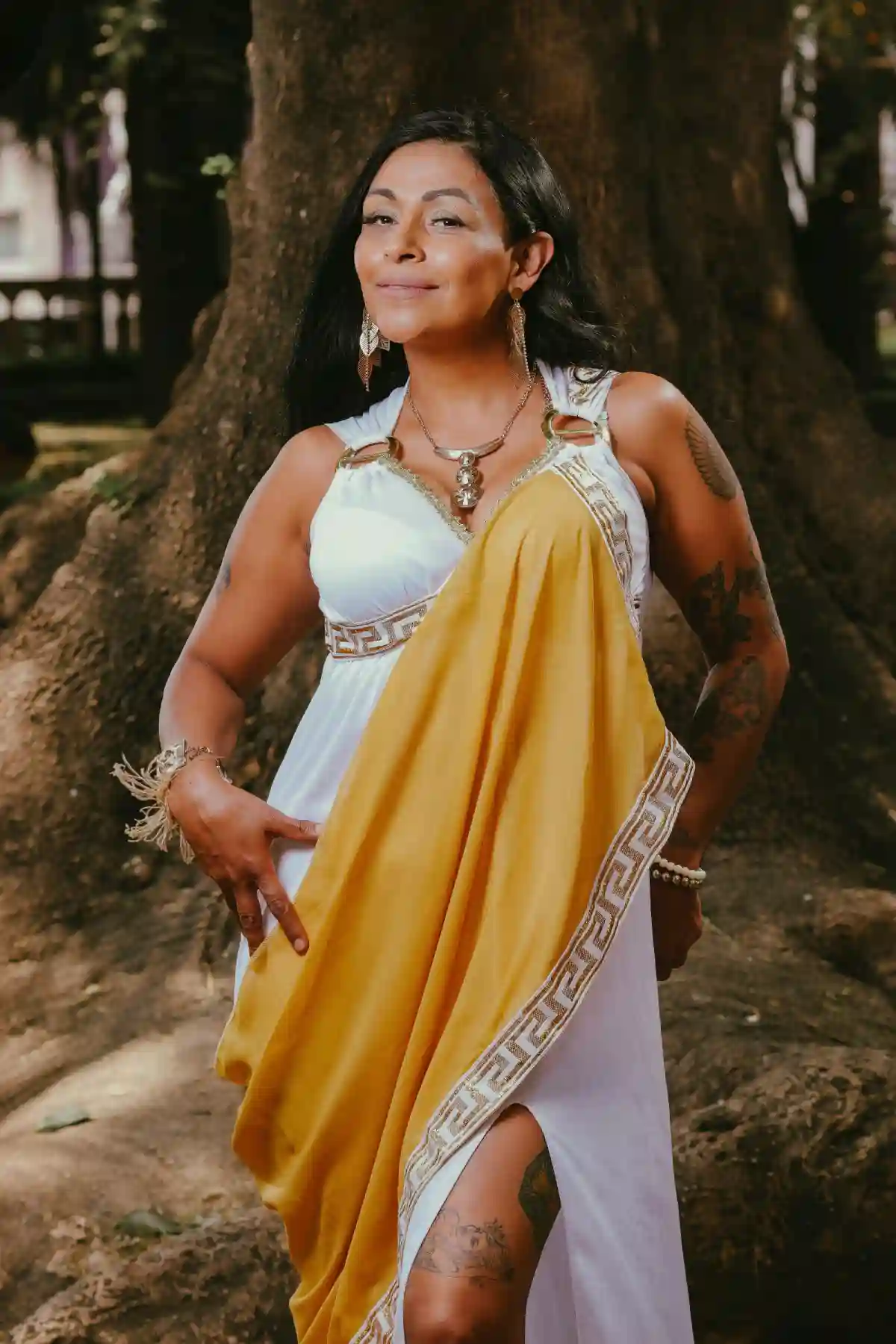 Empowered Woman in Mythological Costume, dressed in a flowing gown and adorned with a laurel crown, standing tall outdoors, embodying strength and wisdom from Greek mythology. Empowered Woman in Mythological Costume, dressed in a flowing gown and adorned with a laurel crown, standing tall outdoors, embodying strength and wisdom from Greek mythology.