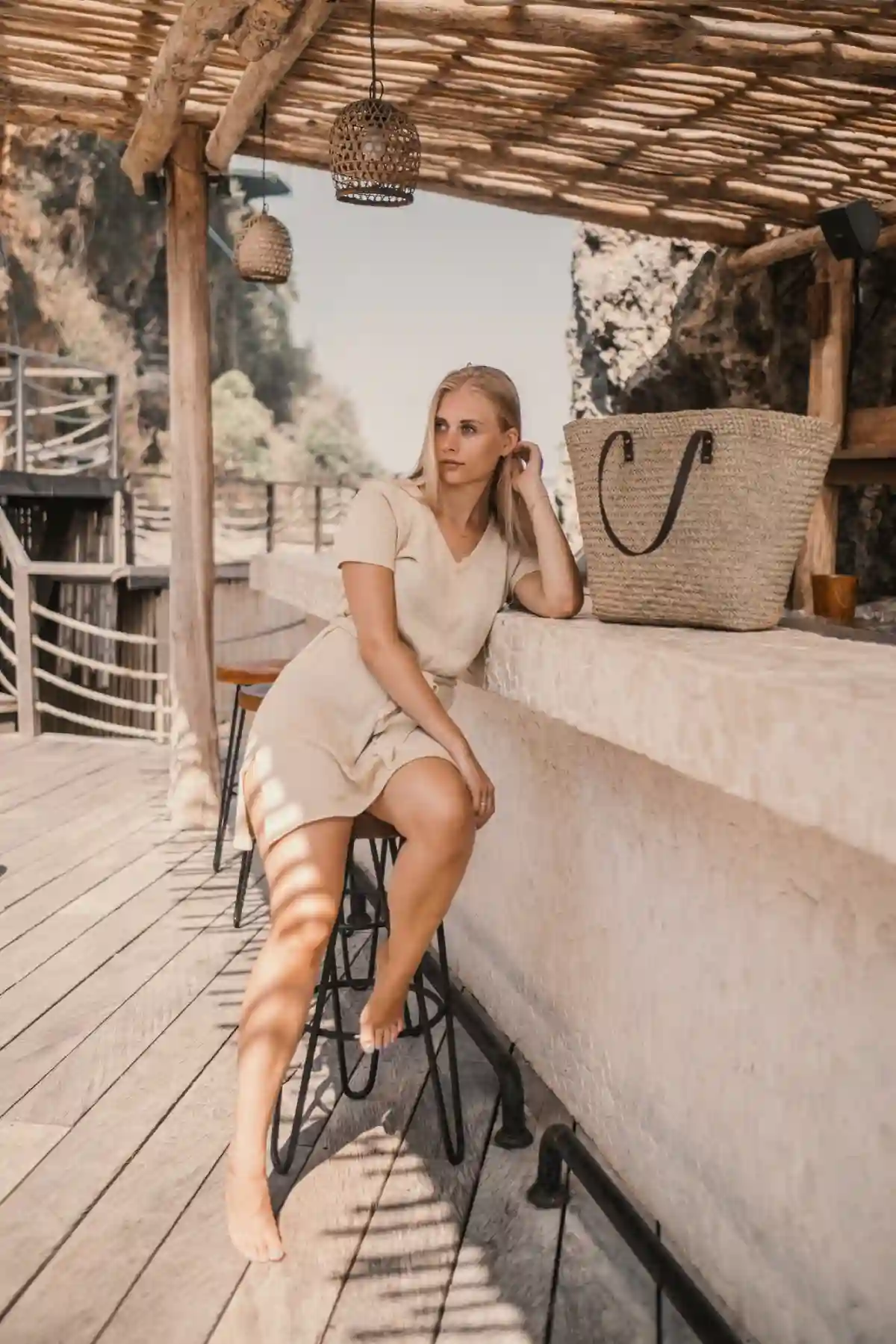 Woman in Modern Greek Fashion sitting next to the bar stand, dressed in a stylish outfit that blends contemporary elegance with classic Greek influences. Woman in Modern Greek Fashion sitting next to the bar stand, dressed in a stylish outfit that blends contemporary elegance with classic Greek influences.