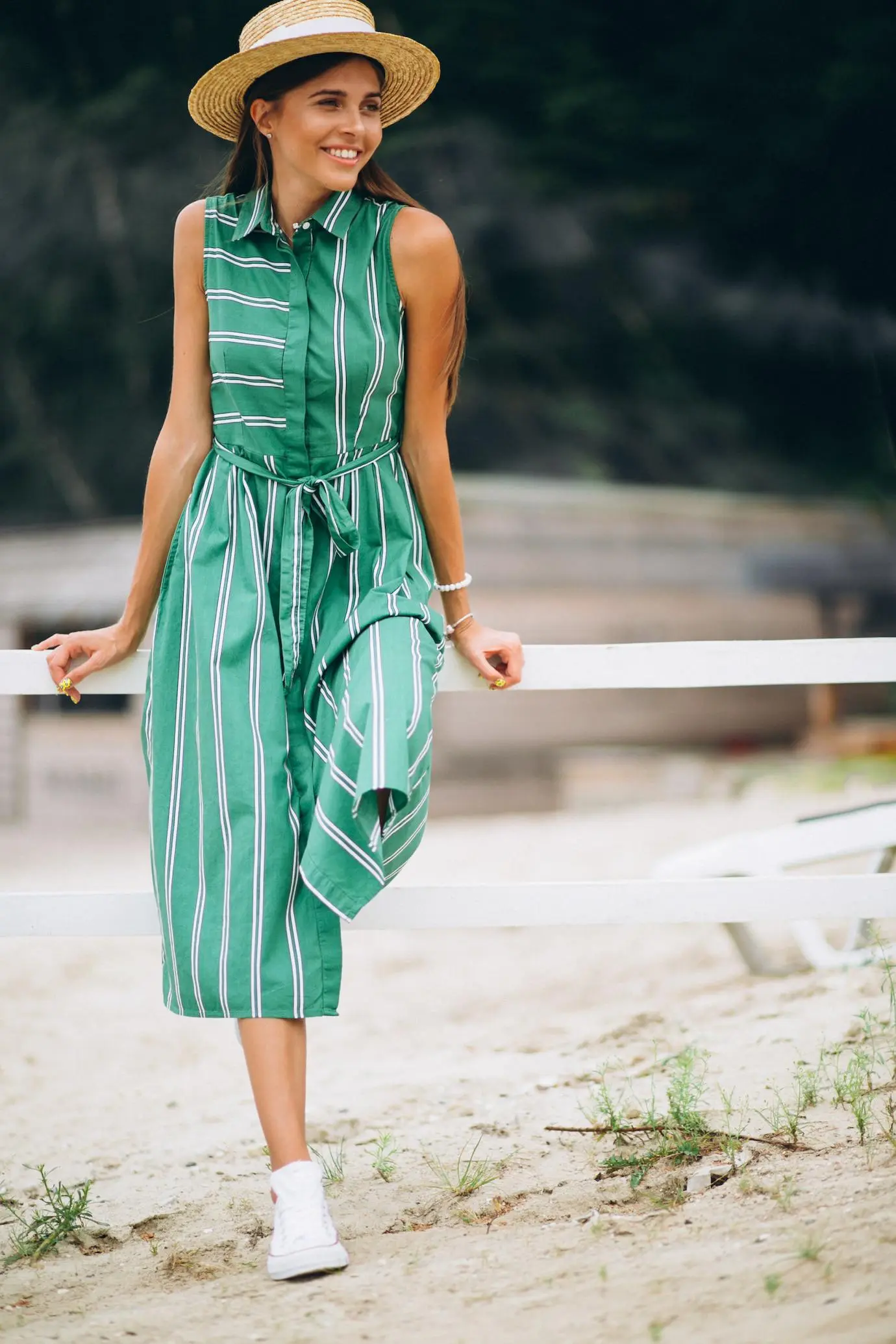 Woman in a green dress standing on the beach, with the ocean and sky in the background. Woman in a green dress standing on the beach, with the ocean and sky in the background.