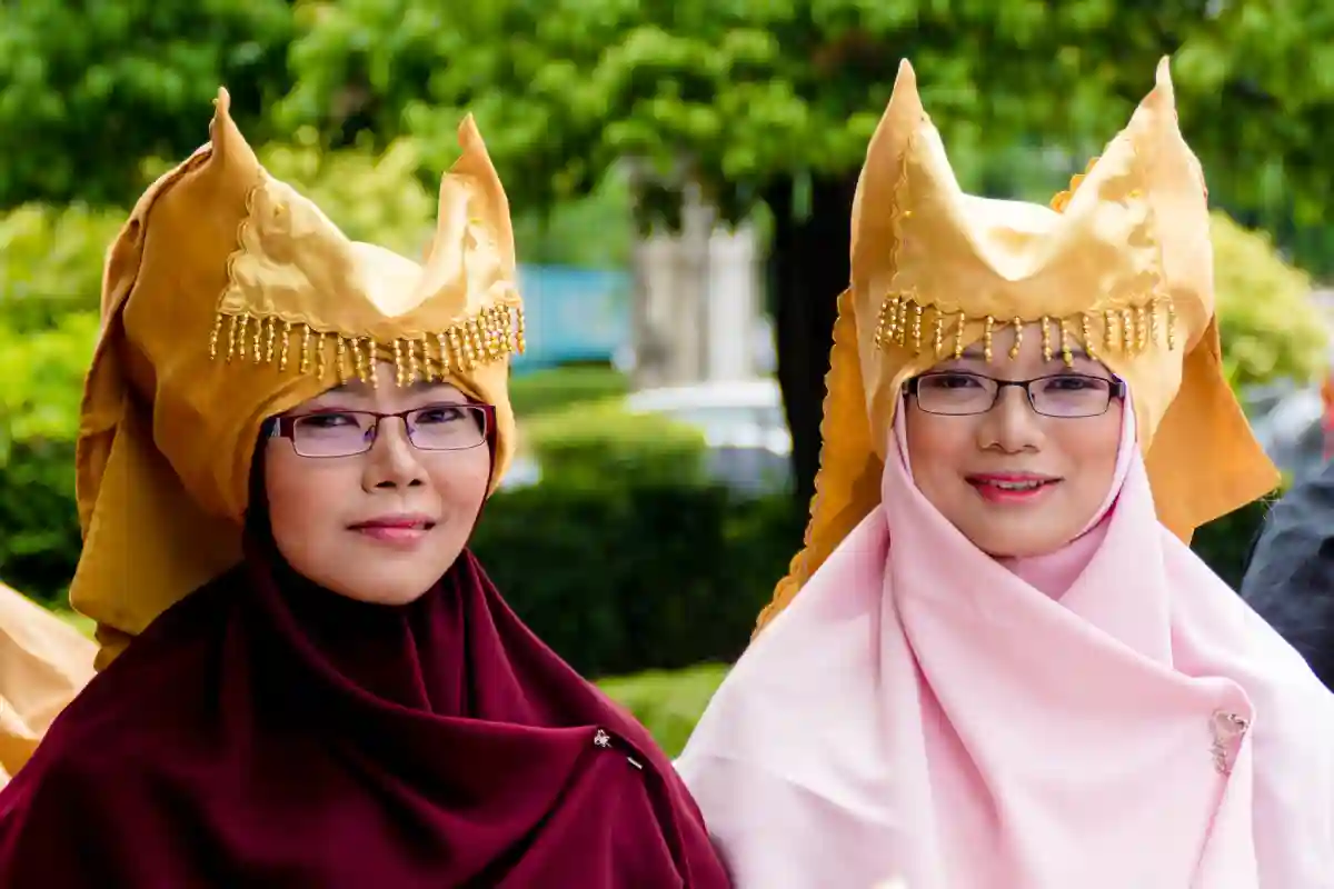 Two Indonesian women in hijabs, standing together, showcasing modest fashion in Java or Bali against a local cultural backdrop. Two Indonesian women in hijabs, standing together, showcasing modest fashion in Java or Bali against a local cultural backdrop.
