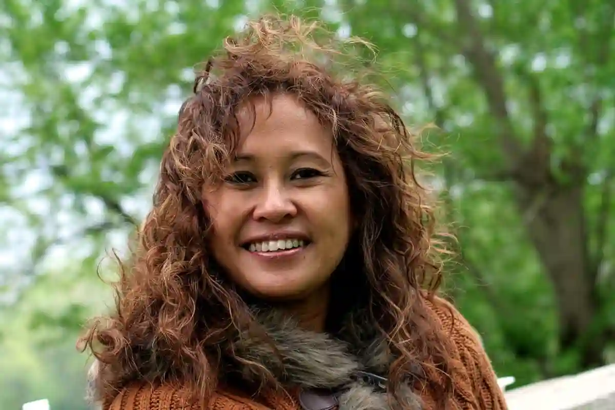 Portrait of a traditional Indonesian woman, dressed in vibrant batik, with long dark hair and a warm, welcoming smile. Portrait of a traditional Indonesian woman, dressed in vibrant batik, with long dark hair and a warm, welcoming smile.