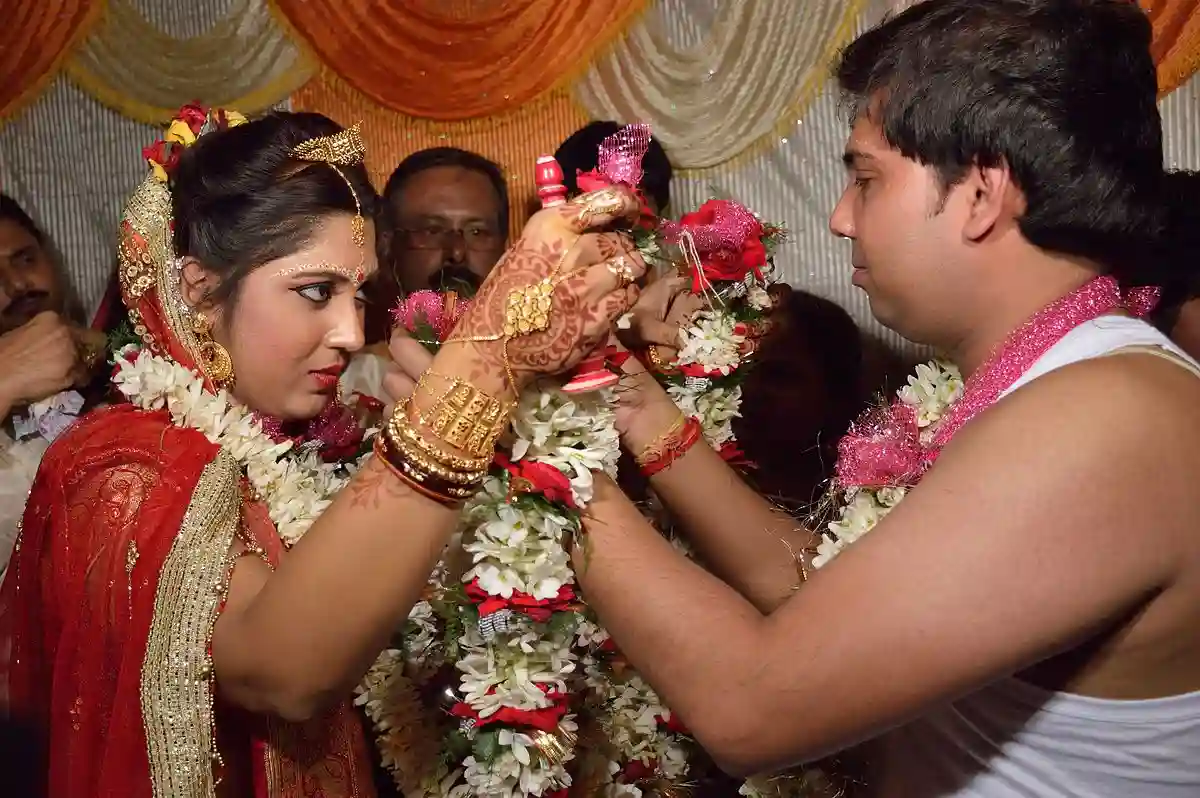 The bride and groom exchange garlands during the Mala Badal ceremony, symbolizing their mutual acceptance and commitment. The bride and groom exchange garlands during the Mala Badal ceremony, symbolizing their mutual acceptance and commitment.