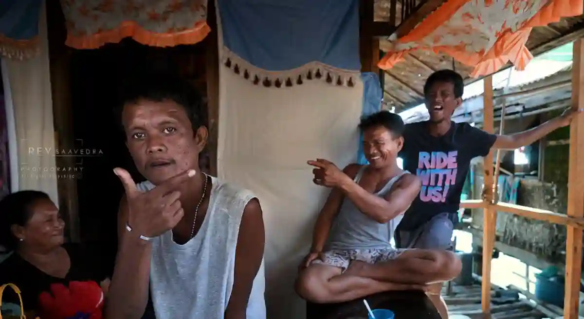A group of Sama-Bajau people in traditional attire, gathered on a boat or in front of their stilt houses over the water, with vibrant expressions of their culture. A group of Sama-Bajau people in traditional attire, gathered on a boat or in front of their stilt houses over the water, with vibrant expressions of their culture.