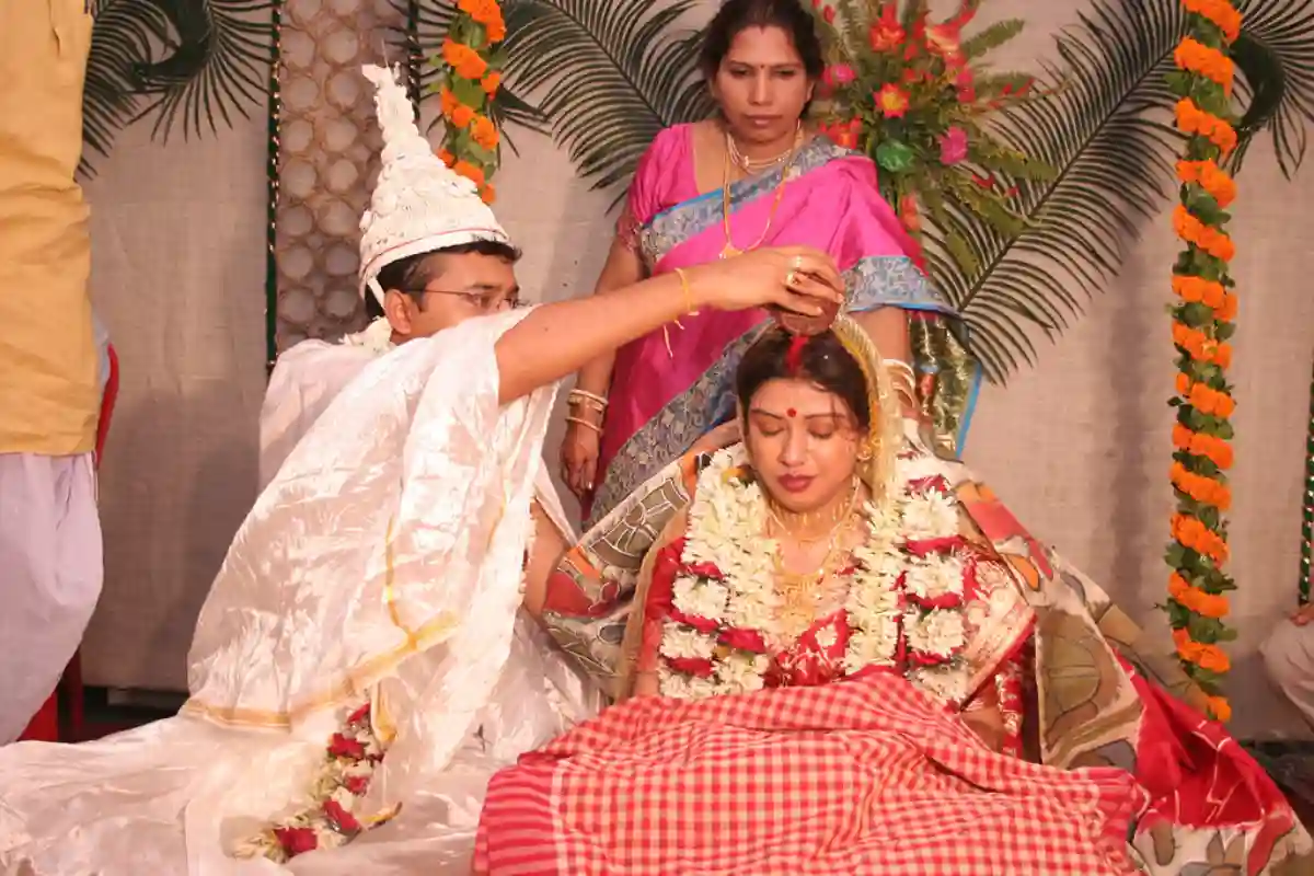 The bride and groom offering rice and prayers during the Anjali ceremony in a traditional Bengali wedding. The bride and groom offering rice and prayers during the Anjali ceremony in a traditional Bengali wedding.