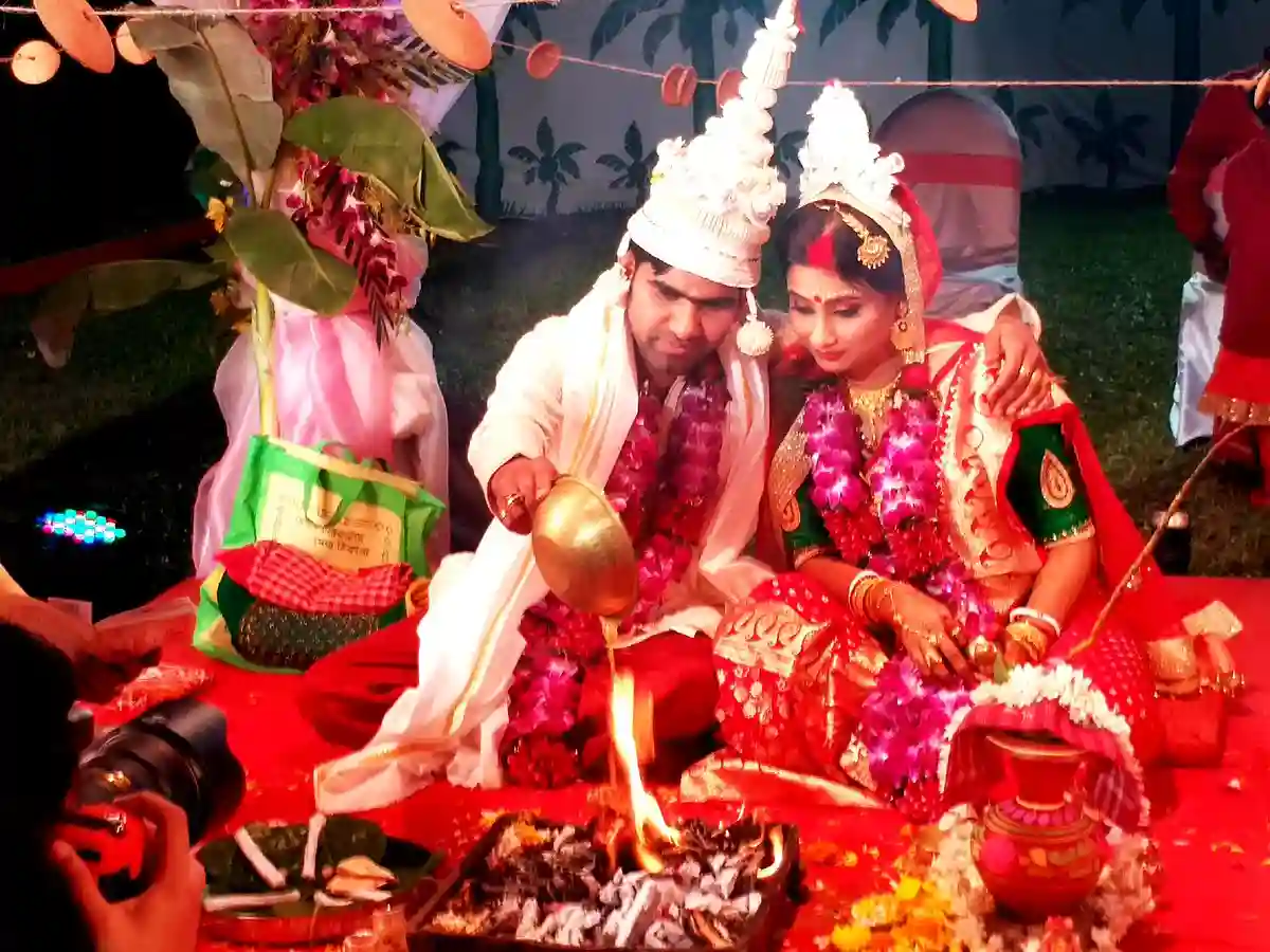 A couple shares a joyful moment during their Bengali wedding, encapsulating the love, happiness, and traditions of the celebration. A couple shares a joyful moment during their Bengali wedding, encapsulating the love, happiness, and traditions of the celebration.