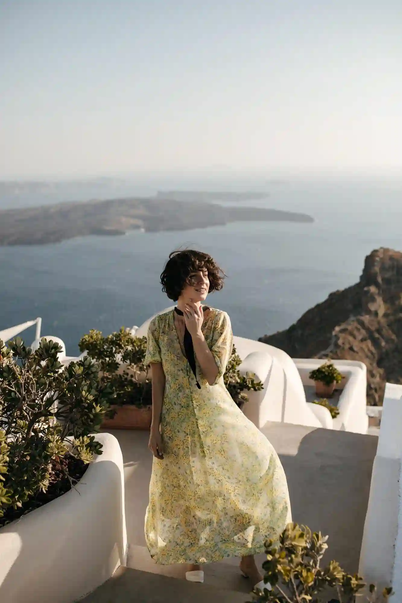 Young brunette woman in a midi dress smiling and enjoying the beautiful sea view. Young brunette woman in a midi dress smiling and enjoying the beautiful sea view.