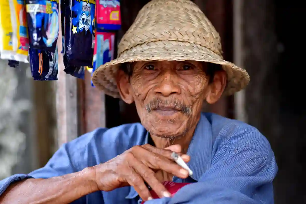 An elderly Indonesian man in traditional attire, sitting peacefully in Bali, embodying the wisdom and cultural heritage of the island. An elderly Indonesian man in traditional attire, sitting peacefully in Bali, embodying the wisdom and cultural heritage of the island.
