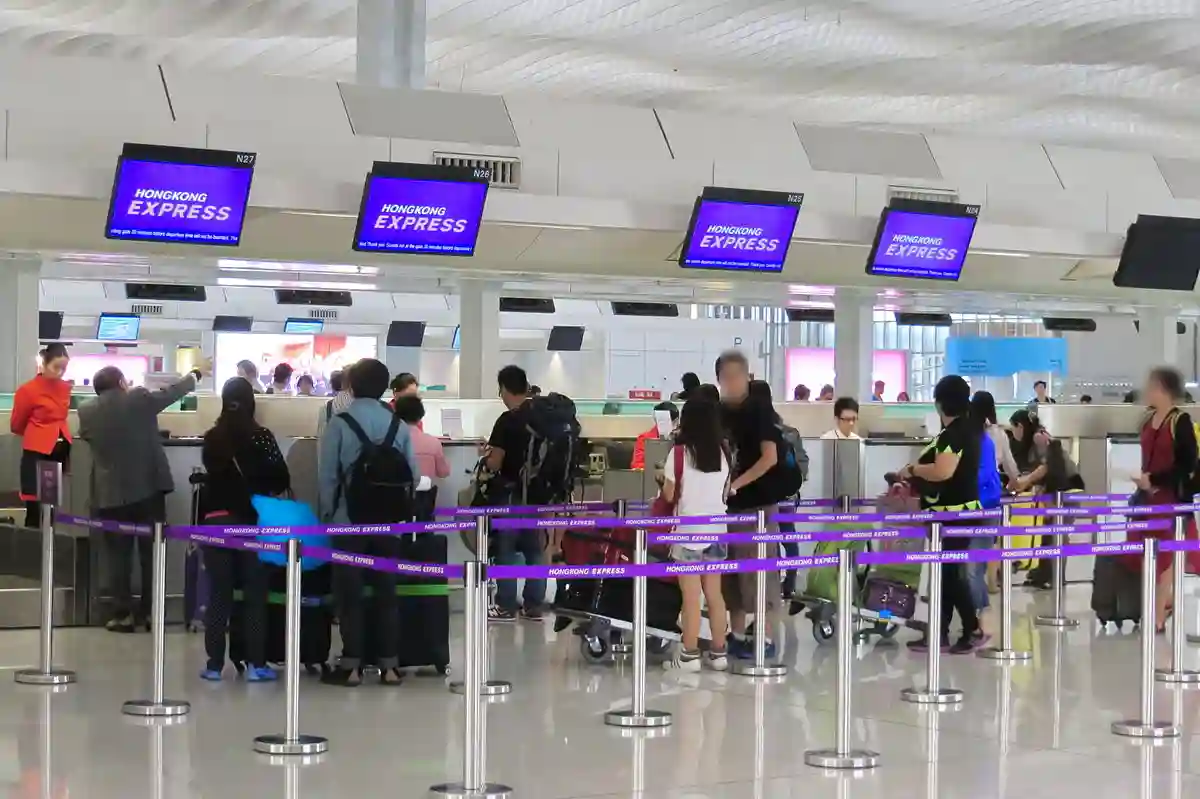 Check-in counter area at Hong Kong International Airport, featuring airlines' counters and travelers preparing for their flights. Check-in counter area at Hong Kong International Airport, featuring airlines' counters and travelers preparing for their flights.