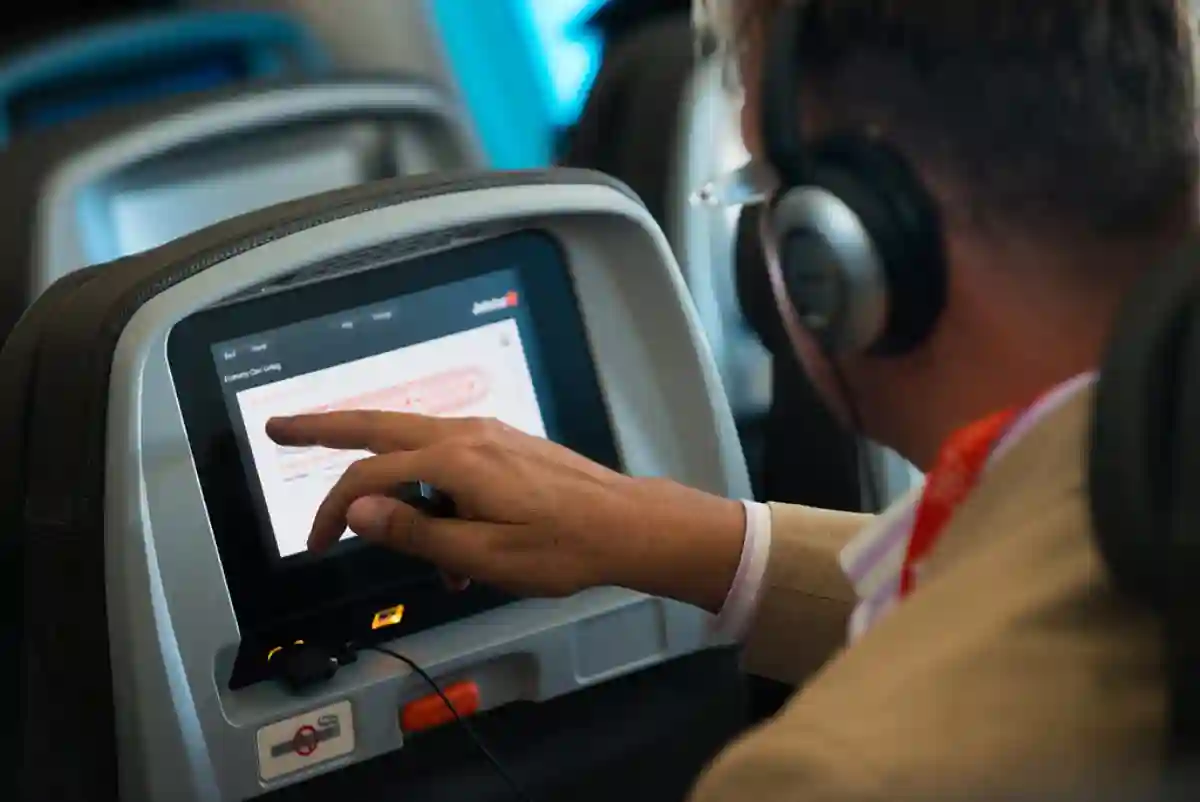 A first-time flyer enjoying in-flight entertainment, watching movies or shows on a personal screen during the flight. A first-time flyer enjoying in-flight entertainment, watching movies or shows on a personal screen during the flight.
