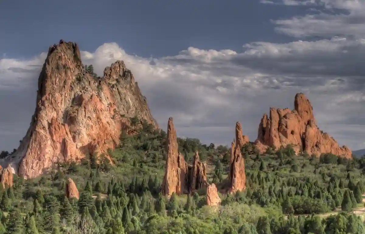 Red rock formations towering against a blue sky at Garden of the Gods, with snow-capped Pikes Peak in the background. Red rock formations towering against a blue sky at Garden of the Gods, with snow-capped Pikes Peak in the background.