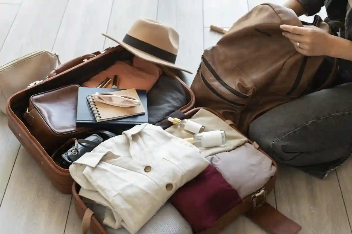 A neatly organized suitcase with clothes, shoes, and accessories like sunglasses, folded neatly for easy packing. A neatly organized suitcase with clothes, shoes, and accessories like sunglasses, folded neatly for easy packing.