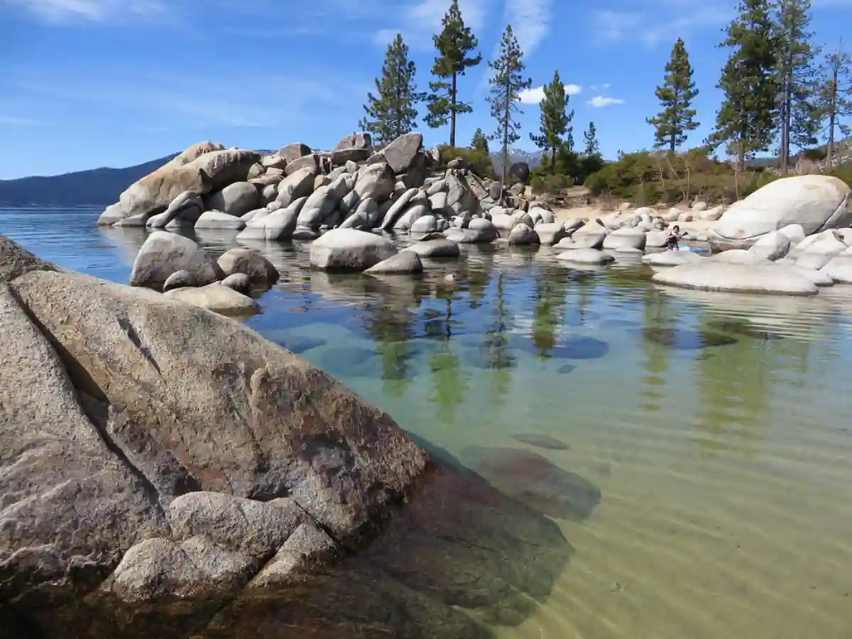 Crystal-clear waters of Sand Harbor at Lake Tahoe State Park, with sandy beaches and towering pine trees, set against a backdrop of the Sierra Nevada mountains. Crystal-clear waters of Sand Harbor at Lake Tahoe State Park, with sandy beaches and towering pine trees, set against a backdrop of the Sierra Nevada mountains.