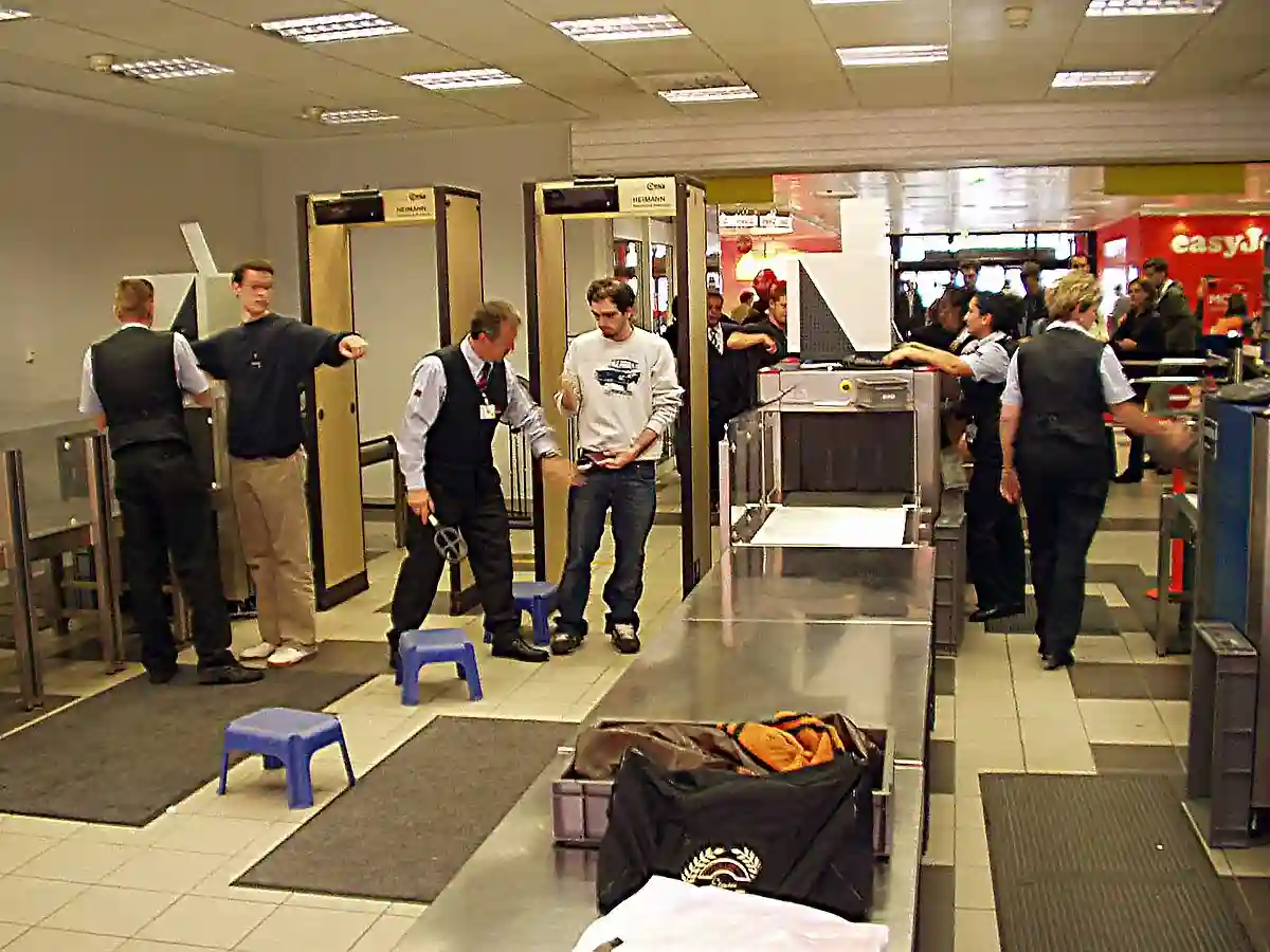 First-time flyers going through airport security, including metal detectors and security personnel assisting travelers First-time flyers going through airport security, including metal detectors and security personnel assisting travelers