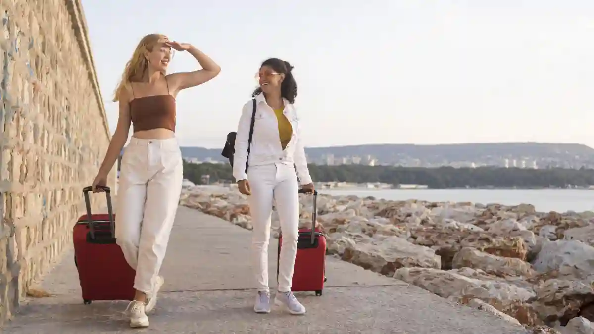 2 happy women dressed in comfortable travel attire, carrying her baggage, and ready to explore new destinations. 2 happy women dressed in comfortable travel attire, carrying her baggage, and ready to explore new destinations.