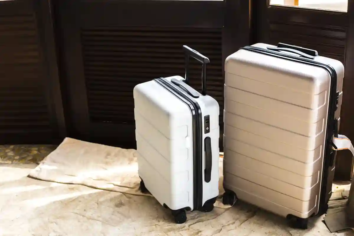 A large suitcase and a carry-on bag, both neatly packed and ready for a trip, placed side by side. A large suitcase and a carry-on bag, both neatly packed and ready for a trip, placed side by side.