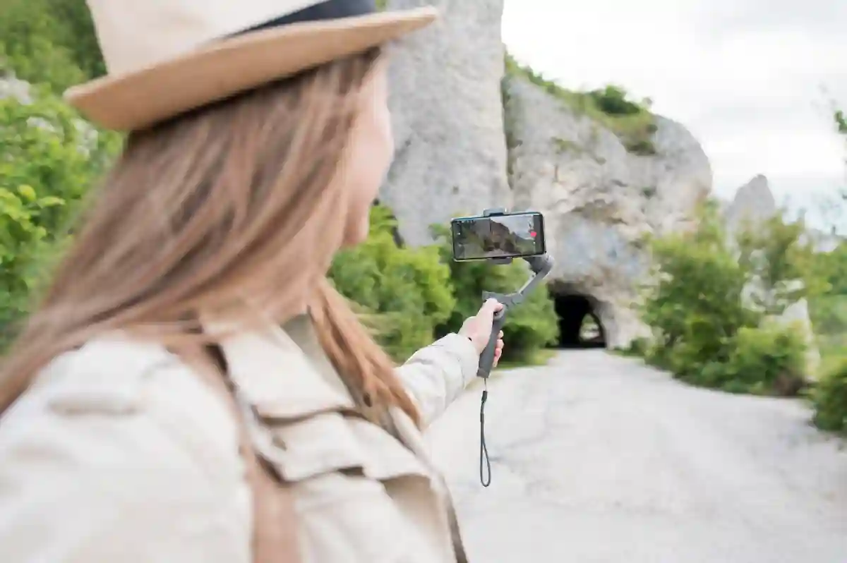 A girl using a selfie stick to photograph nature, with trees, mountains, or a scenic landscape in the background. A girl using a selfie stick to photograph nature, with trees, mountains, or a scenic landscape in the background.
