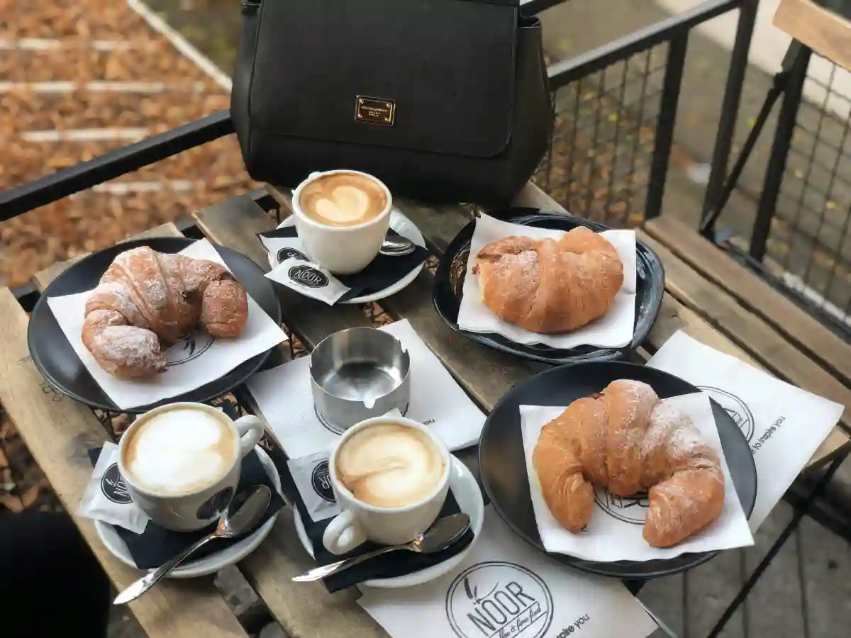 A cozy breakfast scene featuring fresh croissants and a latte on a wooden table, embodying the essence of the best breakfast places in Paris. A cozy breakfast scene featuring fresh croissants and a latte on a wooden table, embodying the essence of the best breakfast places in Paris.
