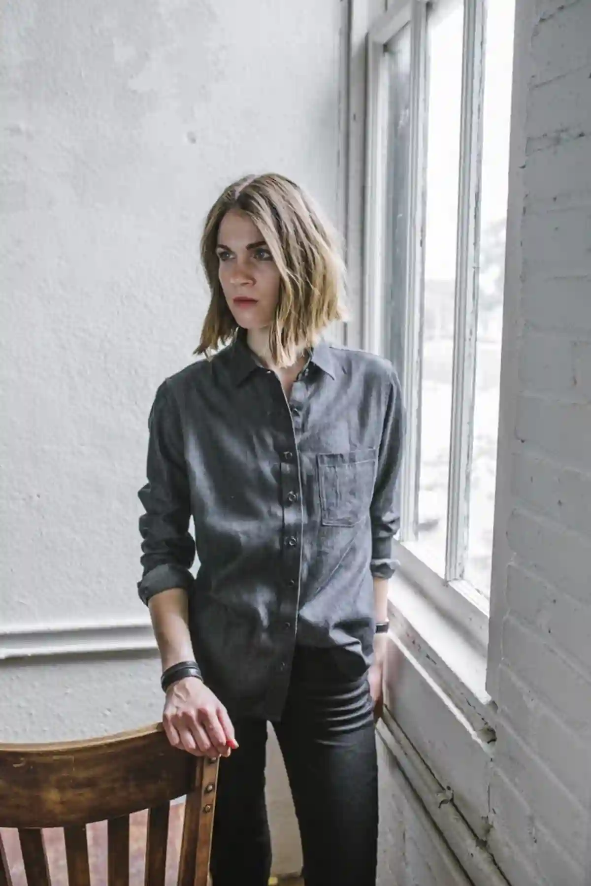 A young woman with a tomboy look, wearing an oversized beige linen shirt and high-waisted dark denim jeans, exuding a perfect blend of masculinity and femininity in her outfit. A young woman with a tomboy look, wearing an oversized beige linen shirt and high-waisted dark denim jeans, exuding a perfect blend of masculinity and femininity in her outfit.