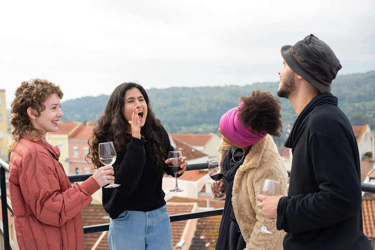 Friends Laughing While Holding Wine Glasses at Portugal